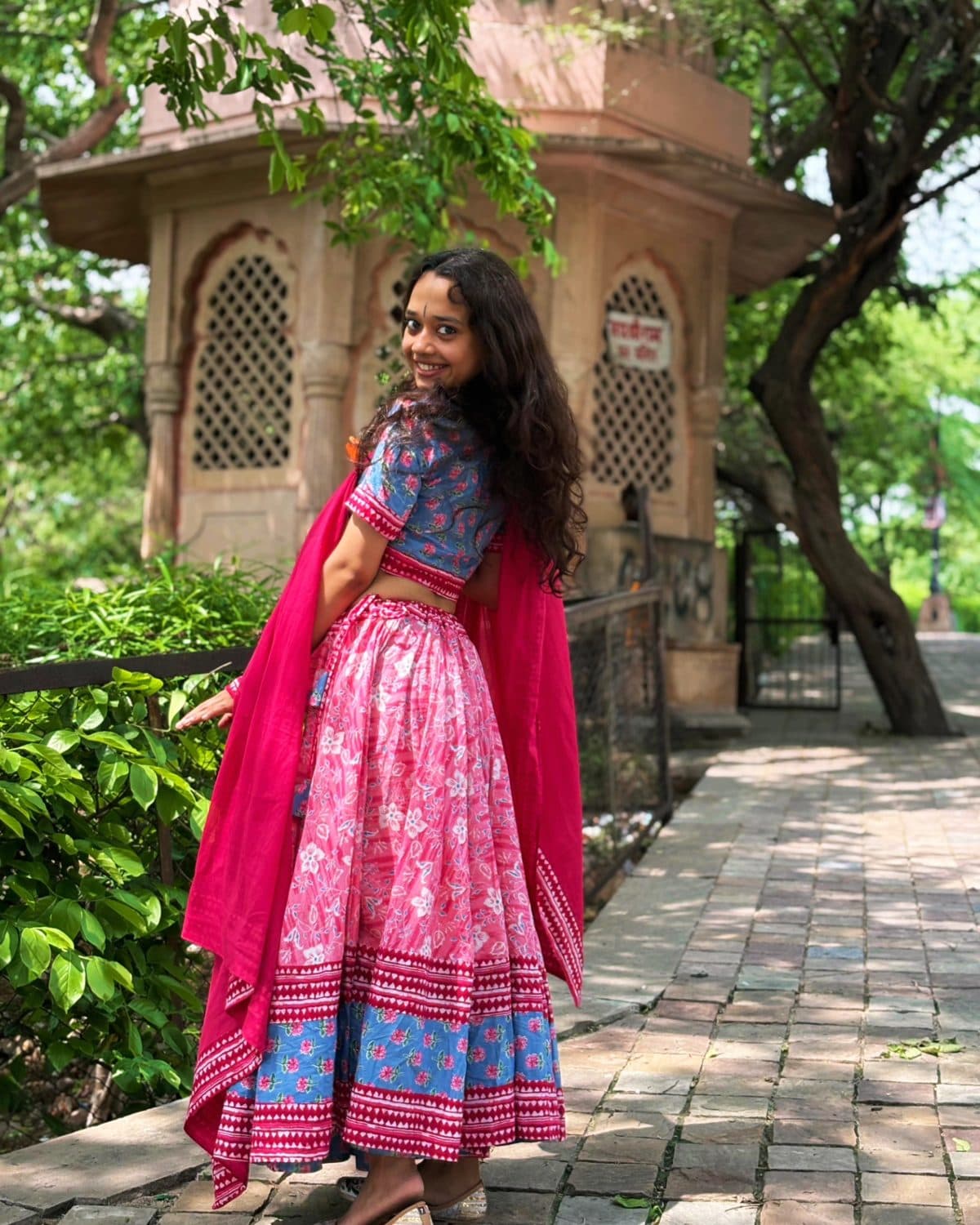 Kishori – Pink floral skirt, blue buti blouse, rani-pink dupatta Gopi Dress